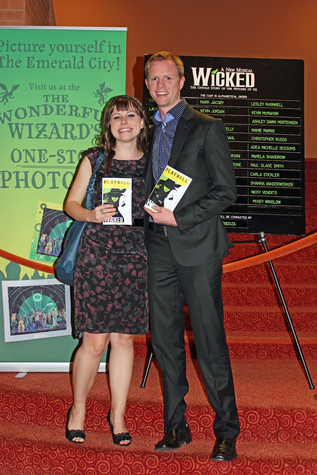 Couple holding the playbill on a Wicked the Musical date night. 