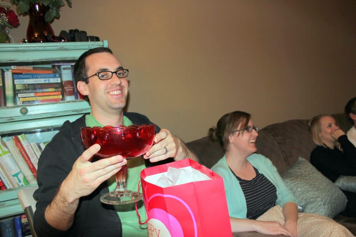 Man holding white elephant party gift. 