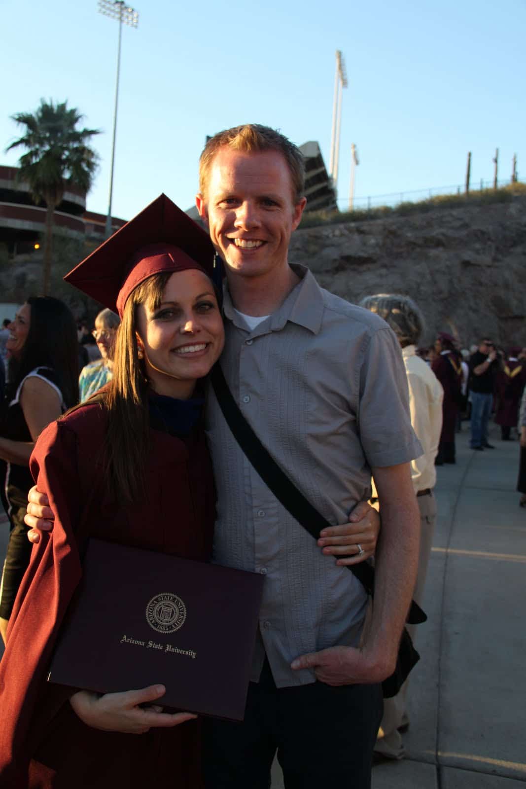 Wife graduating with her MBA with her supportive husband by her side. 