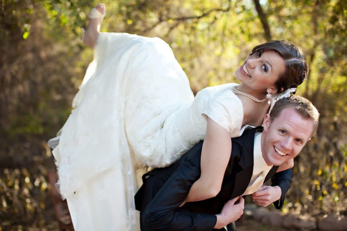 Wife leaning on husband\'s back for a cute wedding picture idea. 