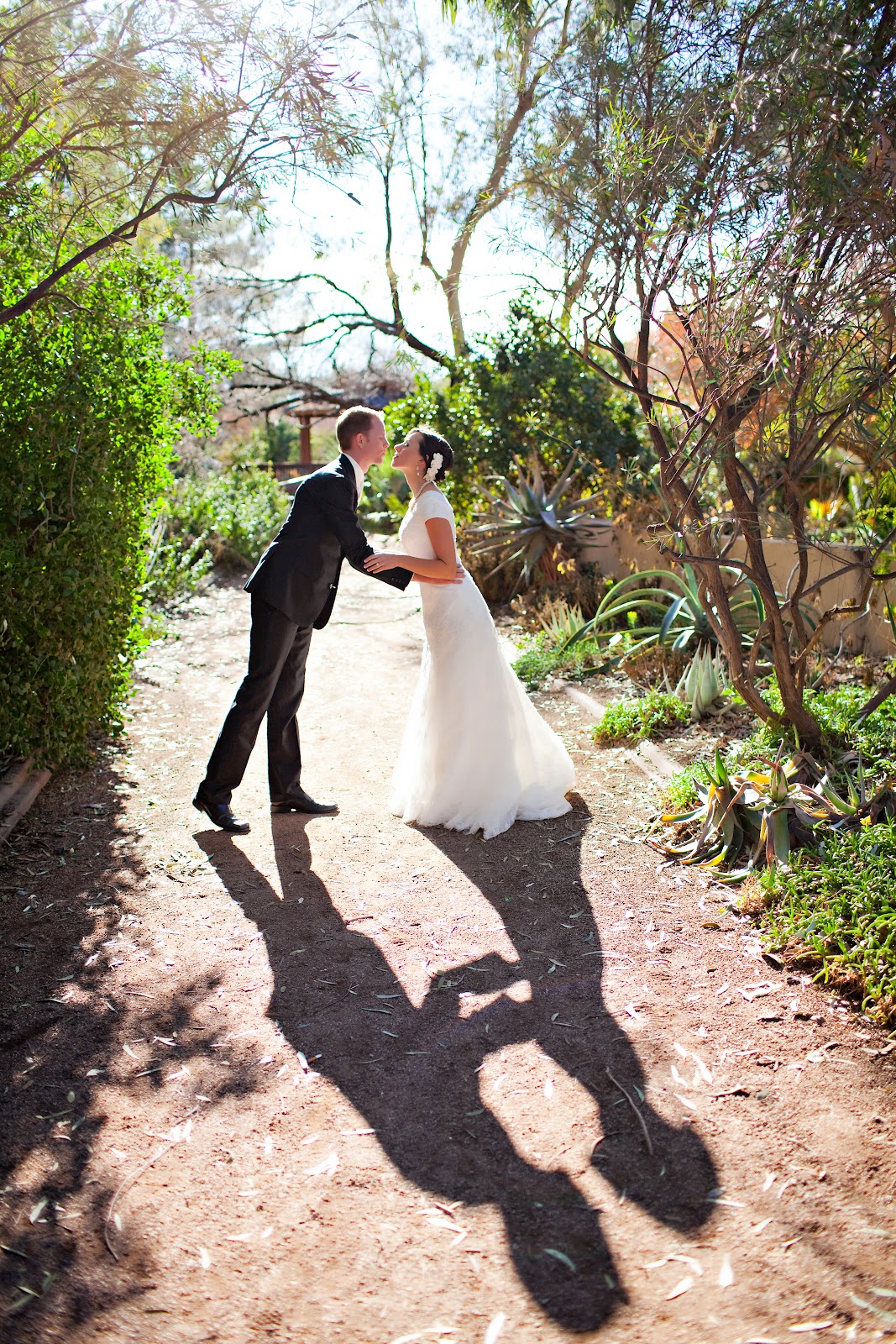 Cute wedding photo idea with a couple kissing and their shadows kissing in front of them. 