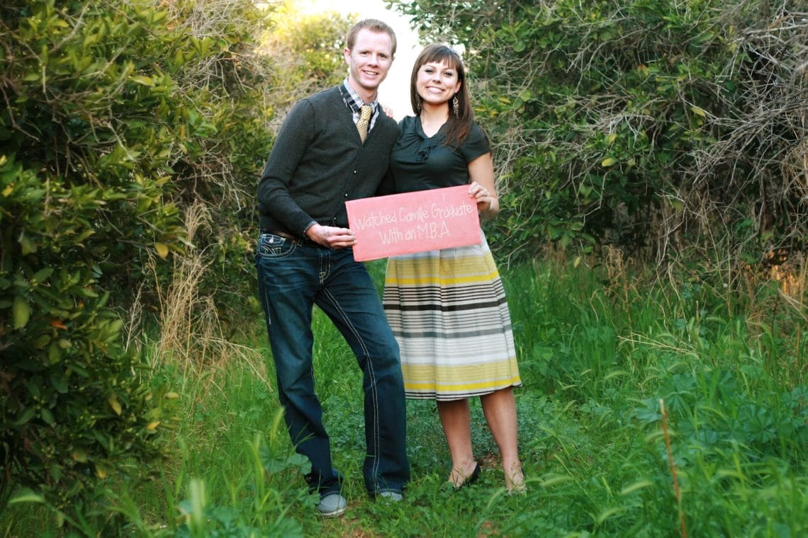 Couple side by side for a anniverary photo shoot holding a sign that says the Highlights of the first year of marriage. 