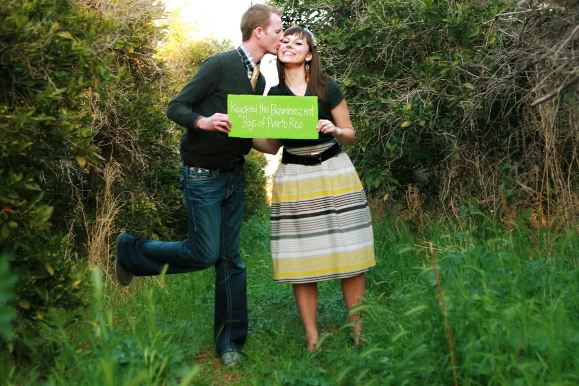 A cute couple holding signs that share the Highlights of the first year of marriage. 