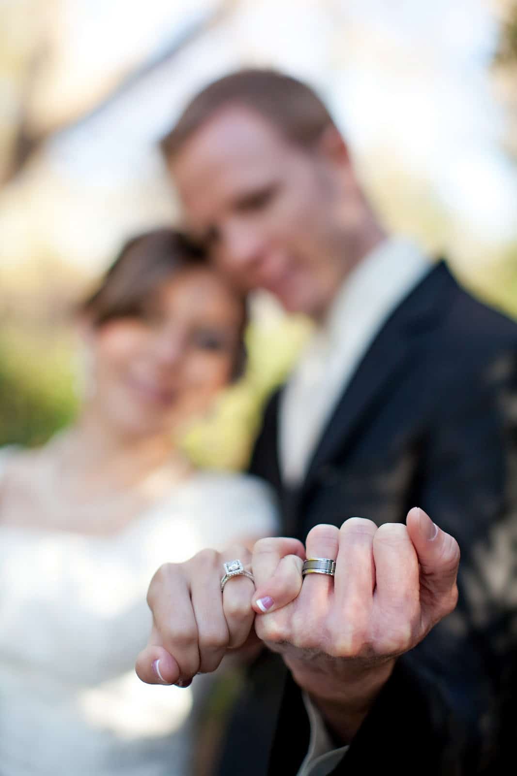 Wedding pictures with a couple locking pinkie fingers and showing off their wedding rings. 