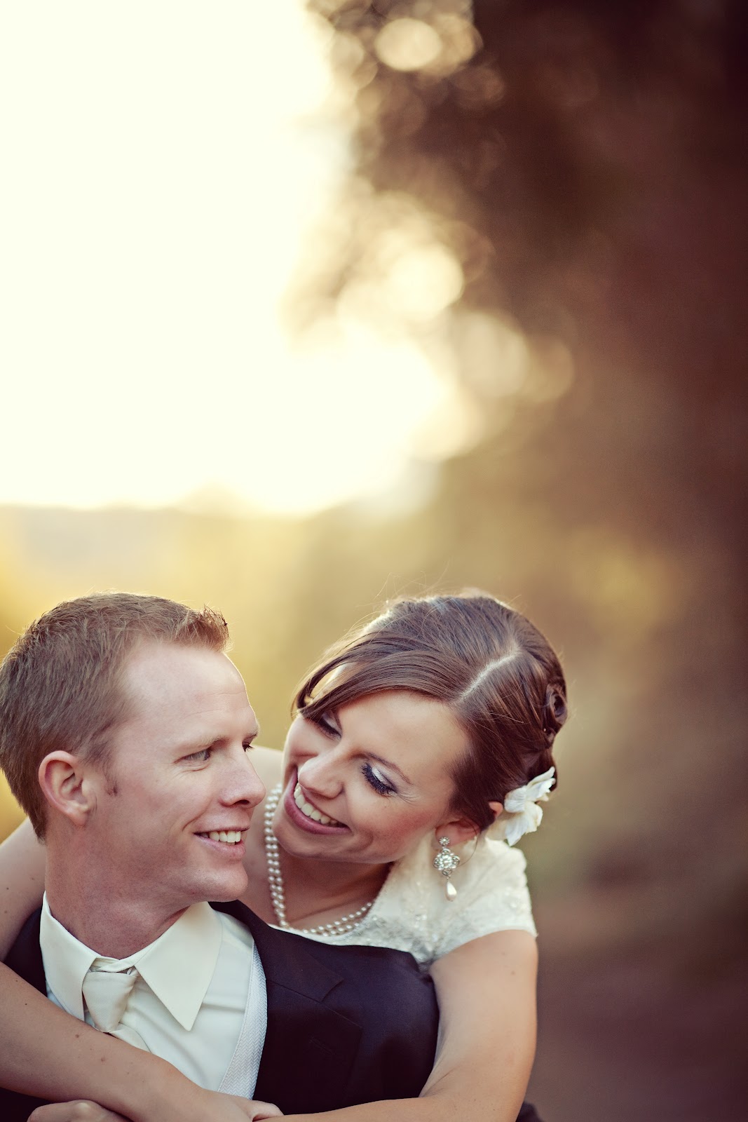 Bridal pictures with the bride on the groom\'s back. 