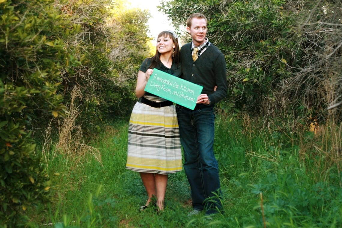 Newlywed couple holding up a sign document the Highlights of the first year of marriage. 