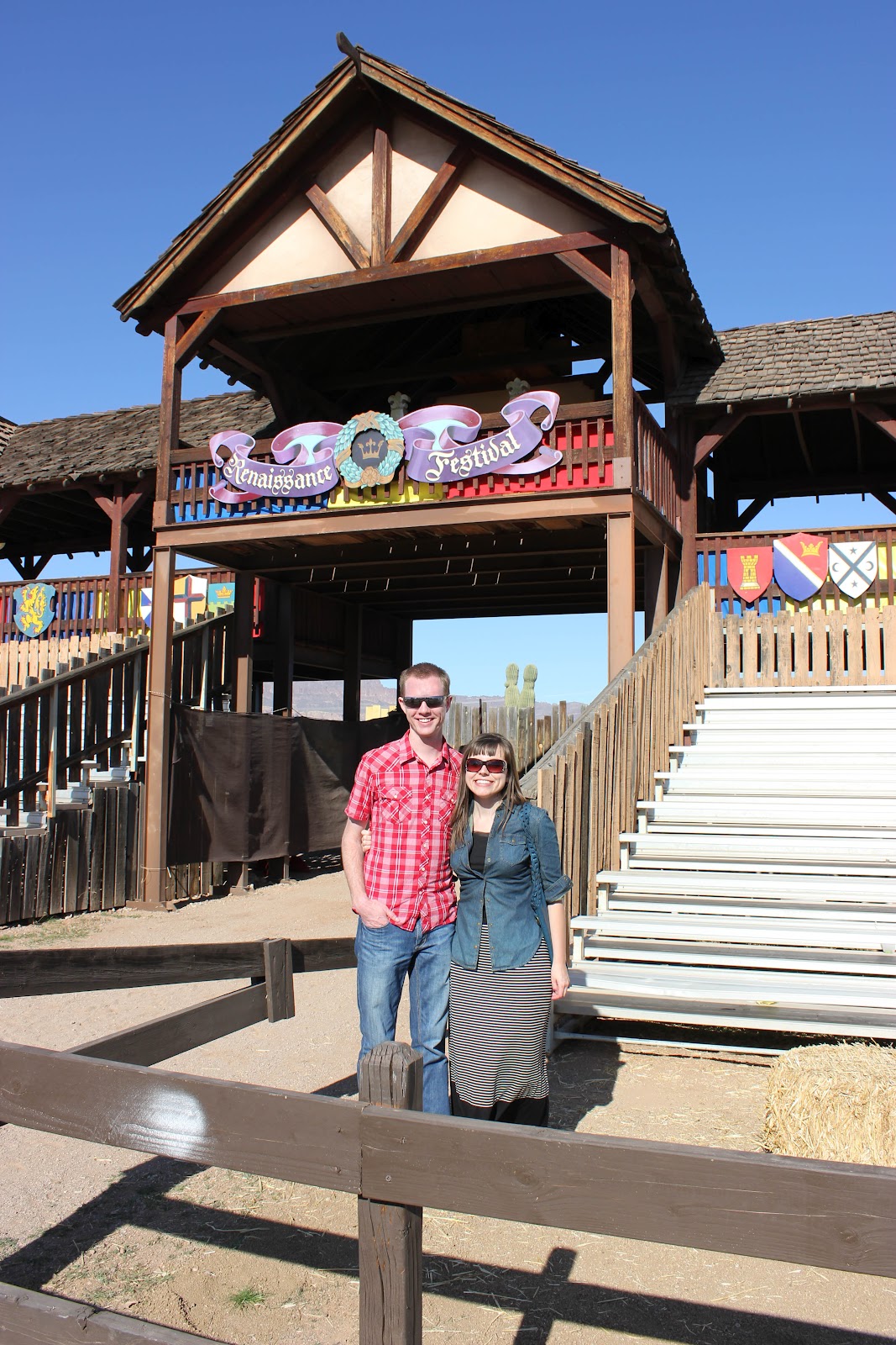 Couple on a date to the Arizona Renaissance Festival in front of the jousting match stands. 