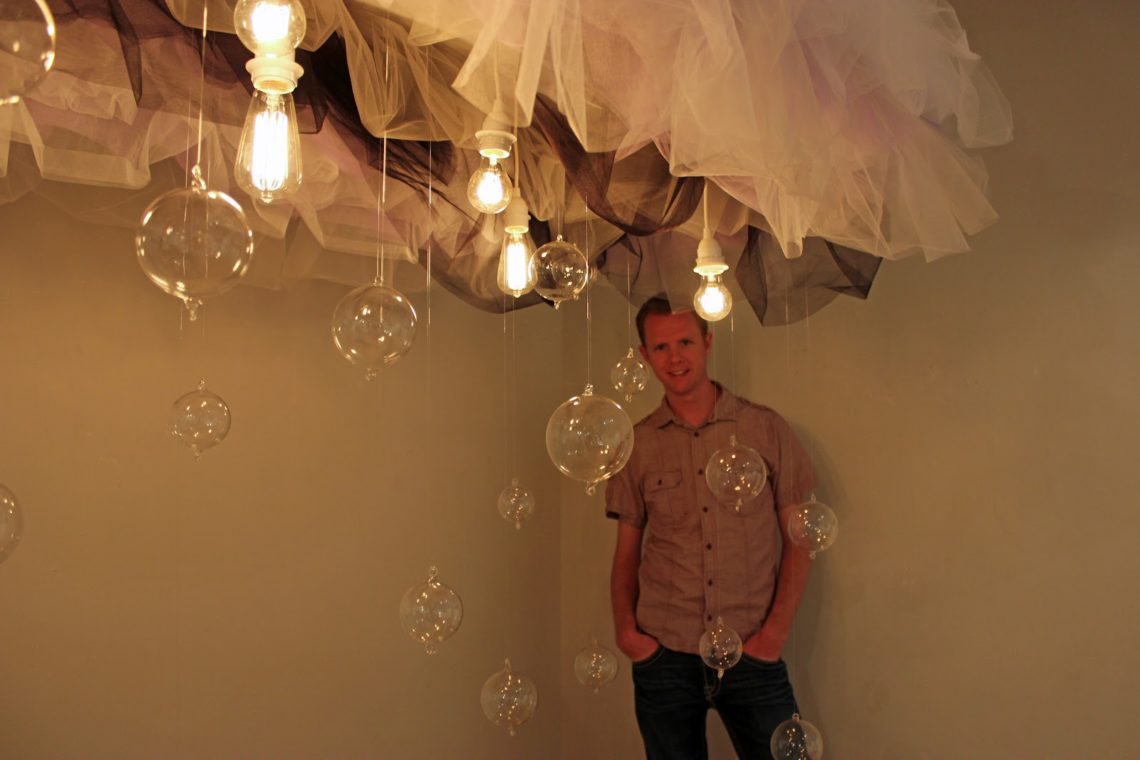 Man in front of art installations at First Friday Art Walk in Phoenix.