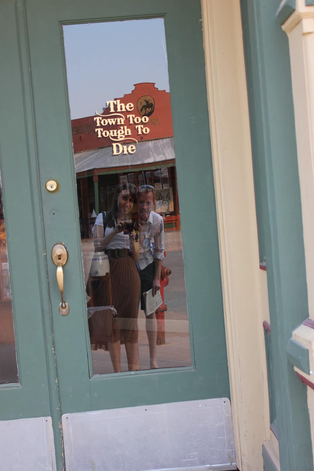 The town too tough to to die painted on a door in Tombstone Arizona. 