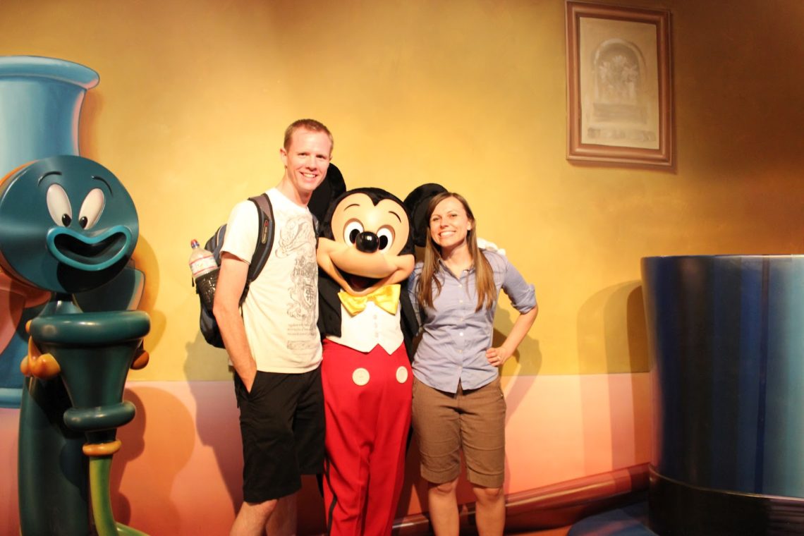 Disneyland date: couple with Mickey Mouse. 