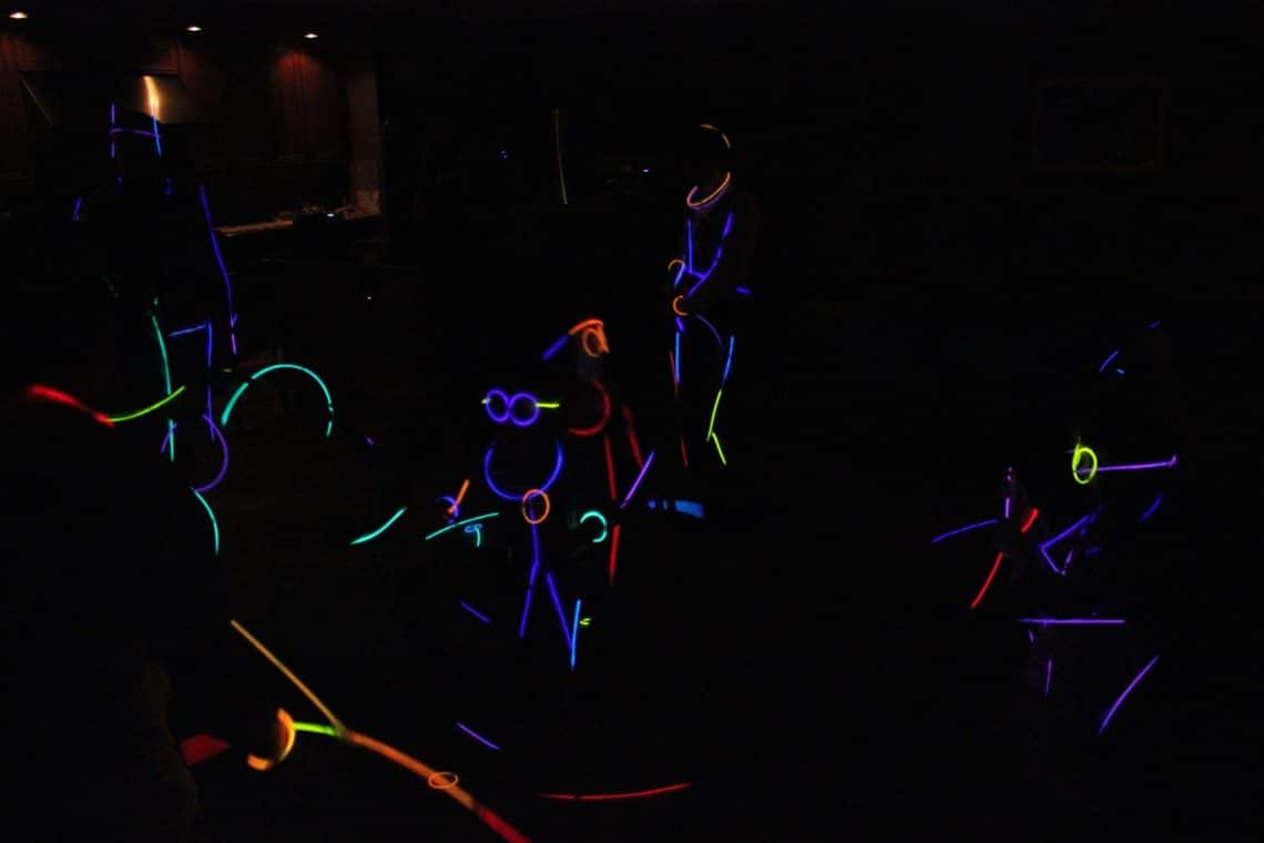 A family enjoying a glow stick dance party. 