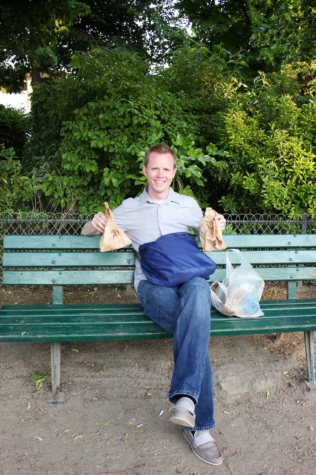Man holding picnic food items for an Eiffel Tower picnic date. 