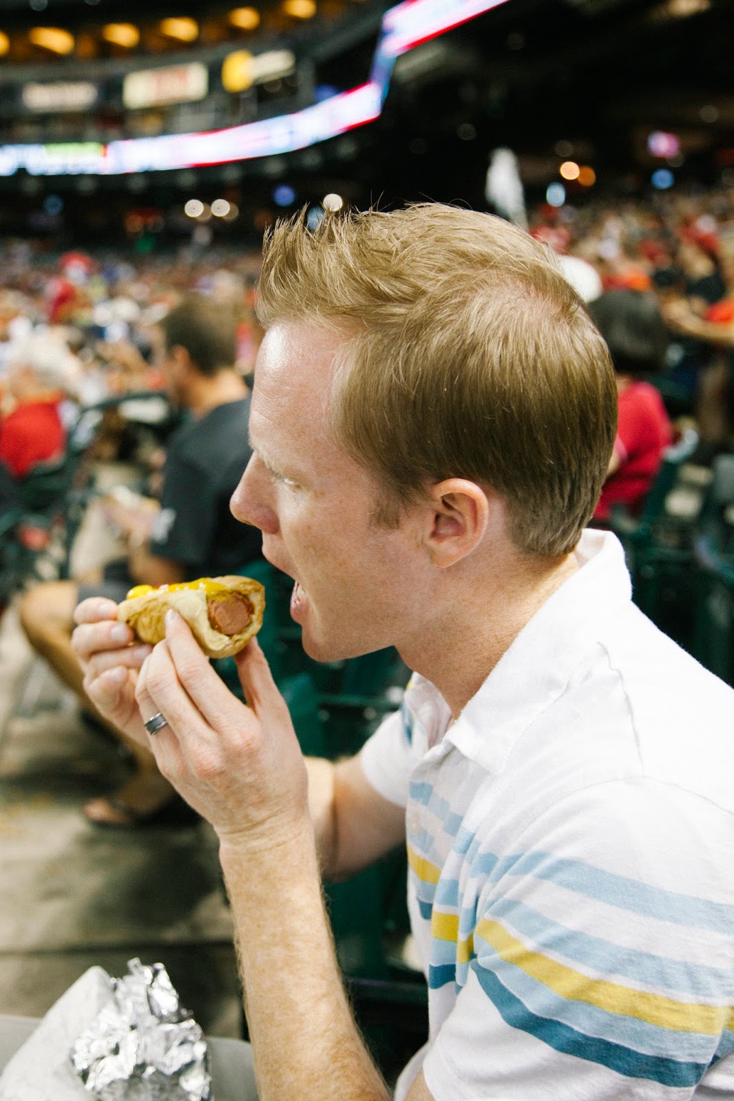 A couple enjoying hot dogs during a Baseball date night. 