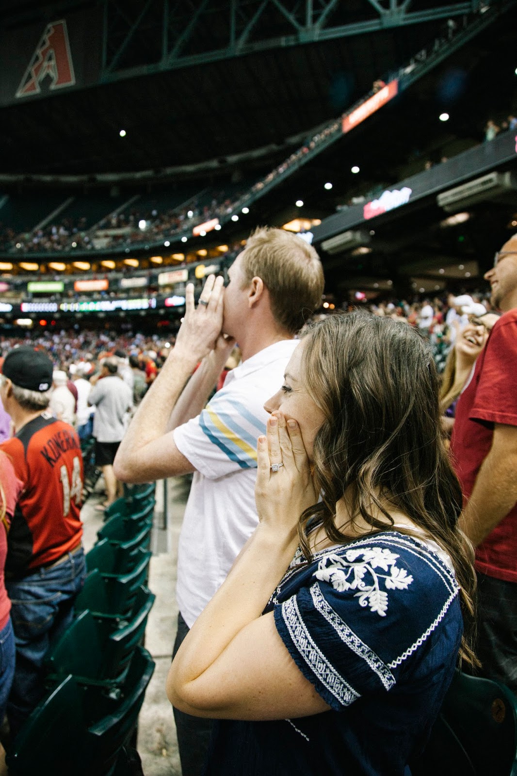 A couple enjoying baseball cheers during a Baseball date night. 