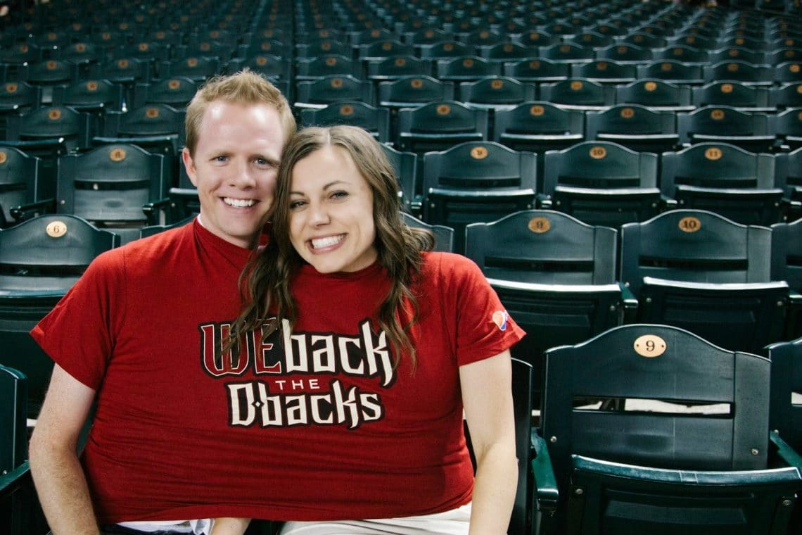 A couple enjoying free shirts during a Baseball date night. 