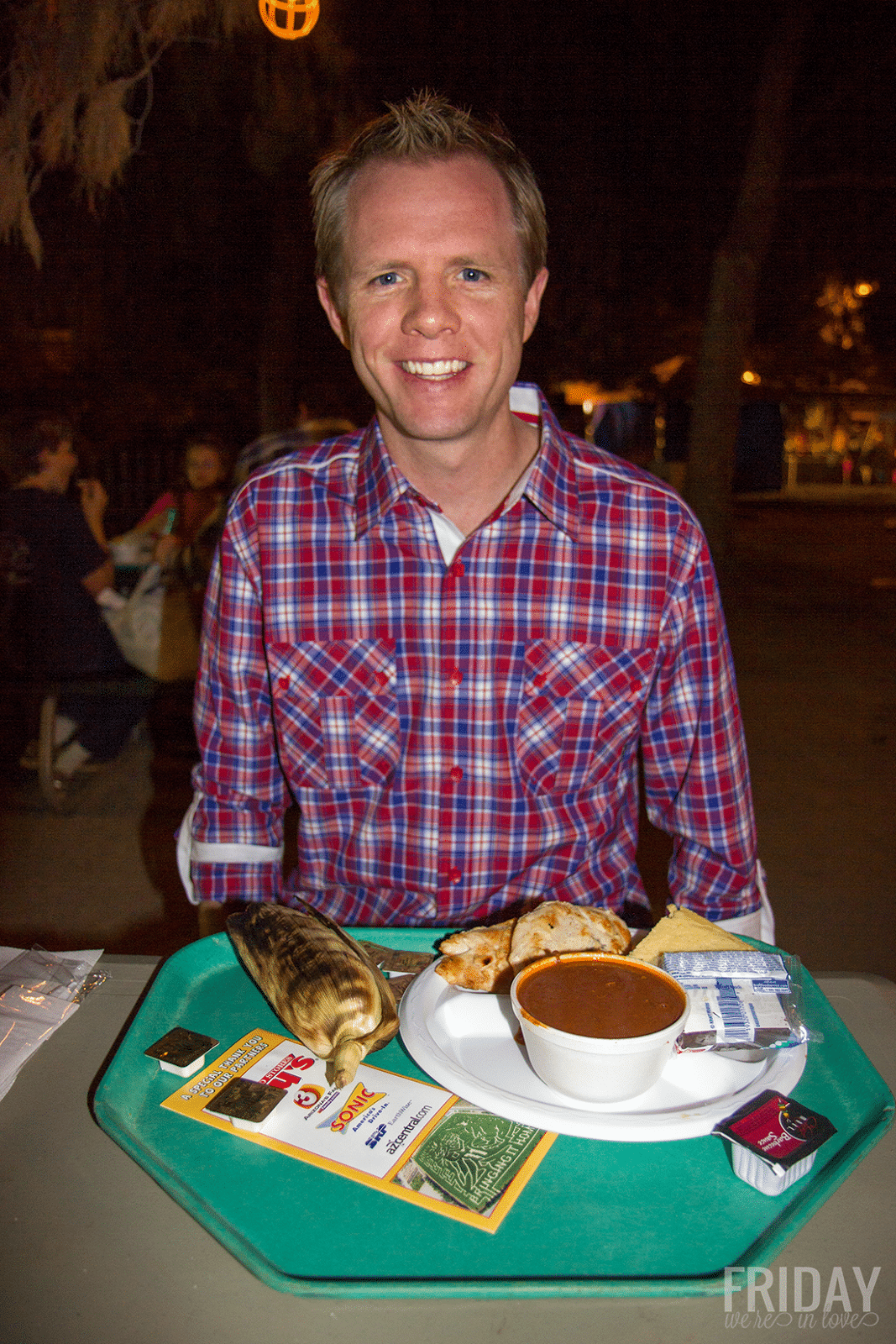 Man enjoying the food at Schnepf Farms Pumpkin and Chili Fest at nighttime. 