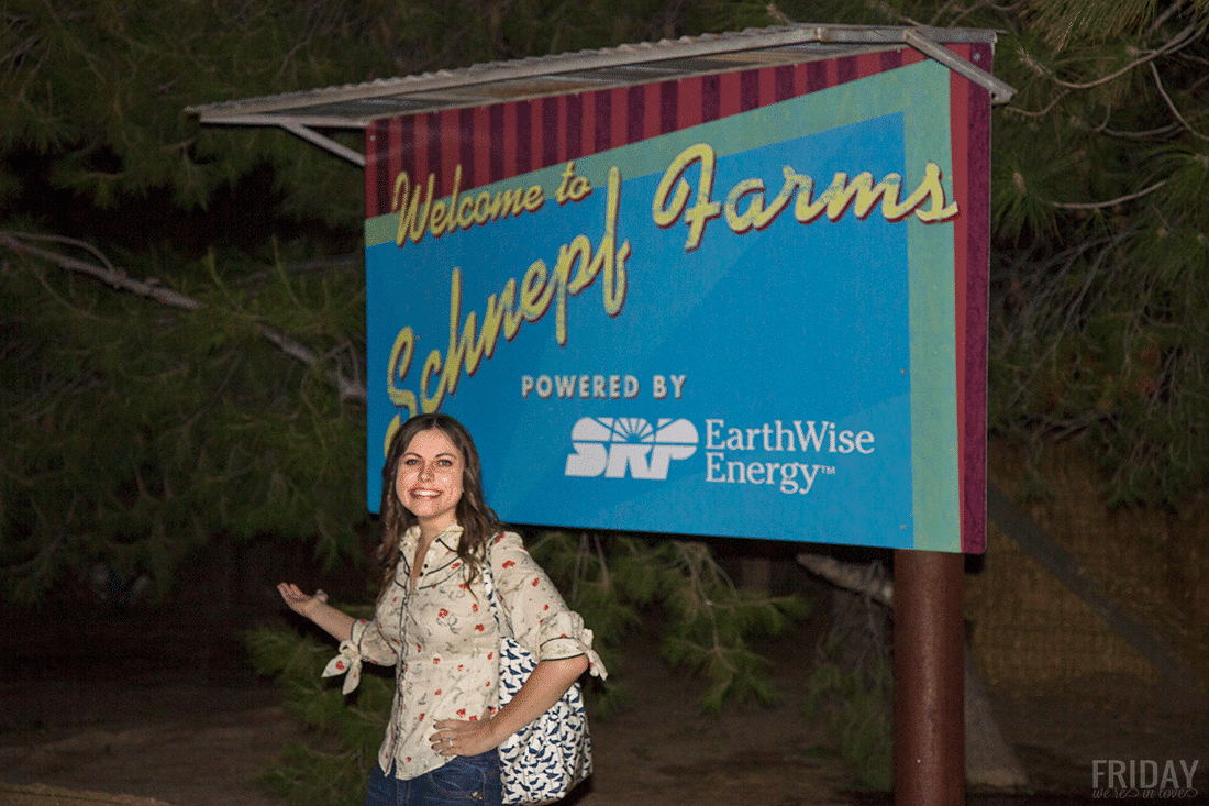 Woman in front of th welcome to Schnepf Farms Pumpkin and Chili Fest sign. 