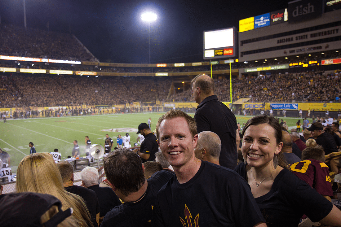 A couple in front of the field at a College Football Game Date