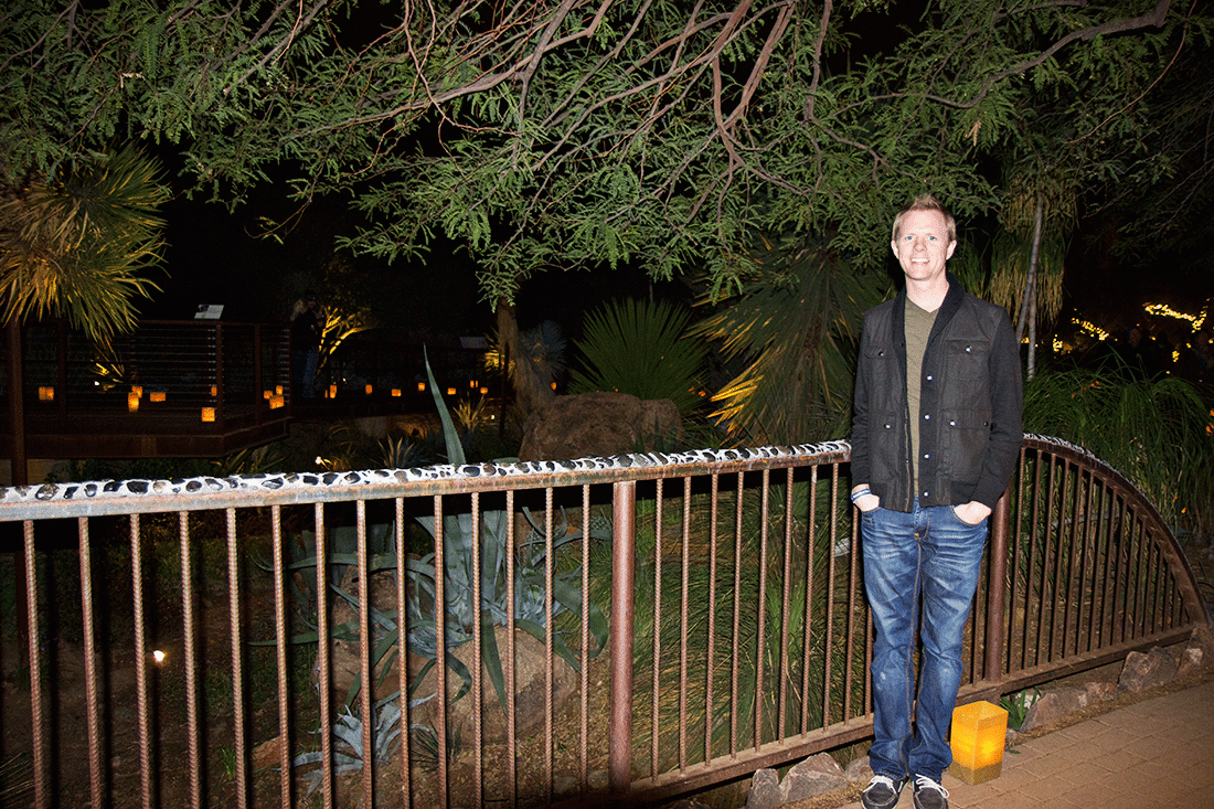 Man in front of lights at Las Noches de Las Luminarias at the Desert Botanical Gardens. 