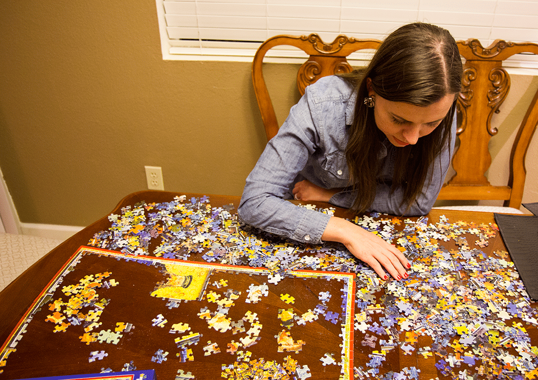 A couple doing a jigsaw puzzle for a puzzle date night at home. 