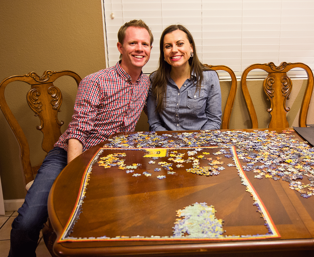 Couple doing a jigsaw puzzle for a puzzle date night at home. 