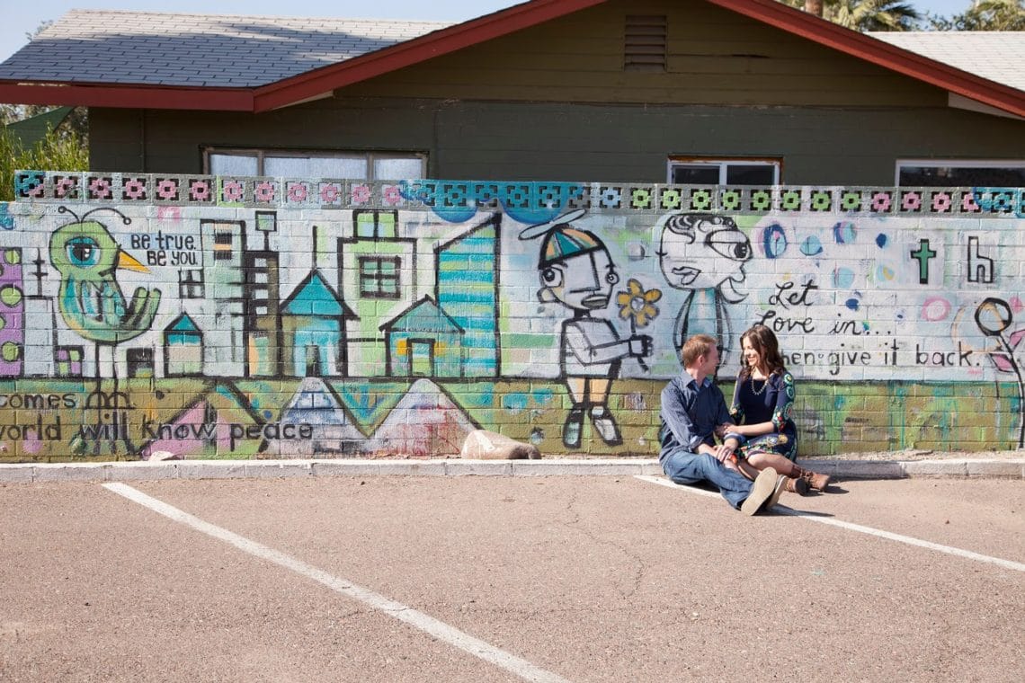 Couple in front of Downtown Phoenix murals. 