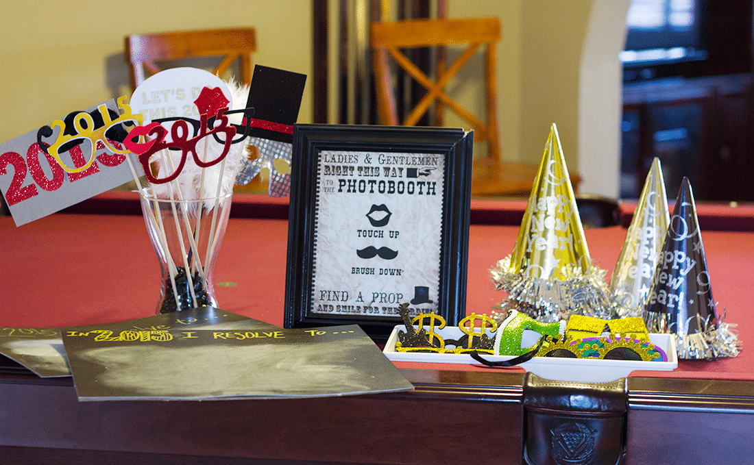 New Year\'s Eve photobooth props with a sign on a table. 