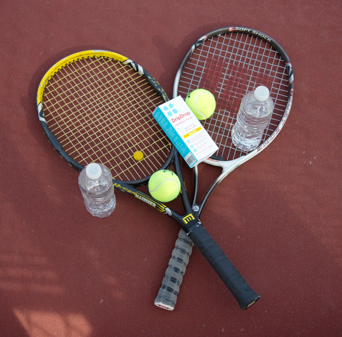 Tennis raquets played out with water bottles and tennis balls. 