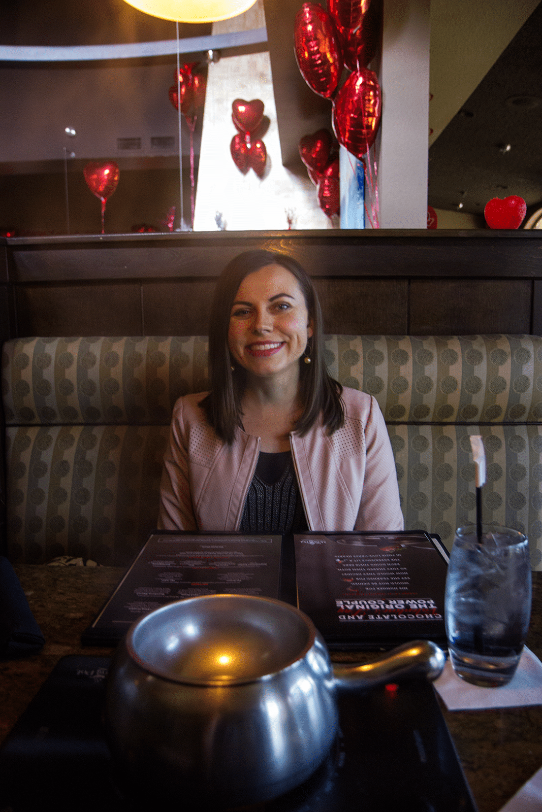 Woman sitting in a bench ready for a fondue date at the Melting Pot. 