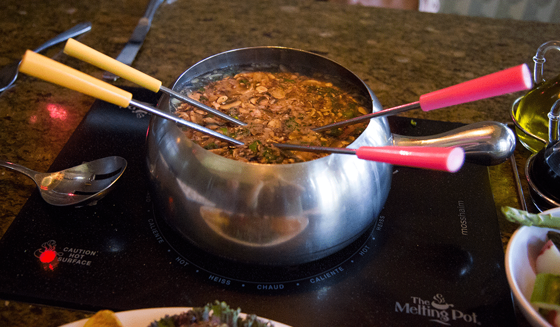 Cooking meat in fondue pot at The Melting Pot. 