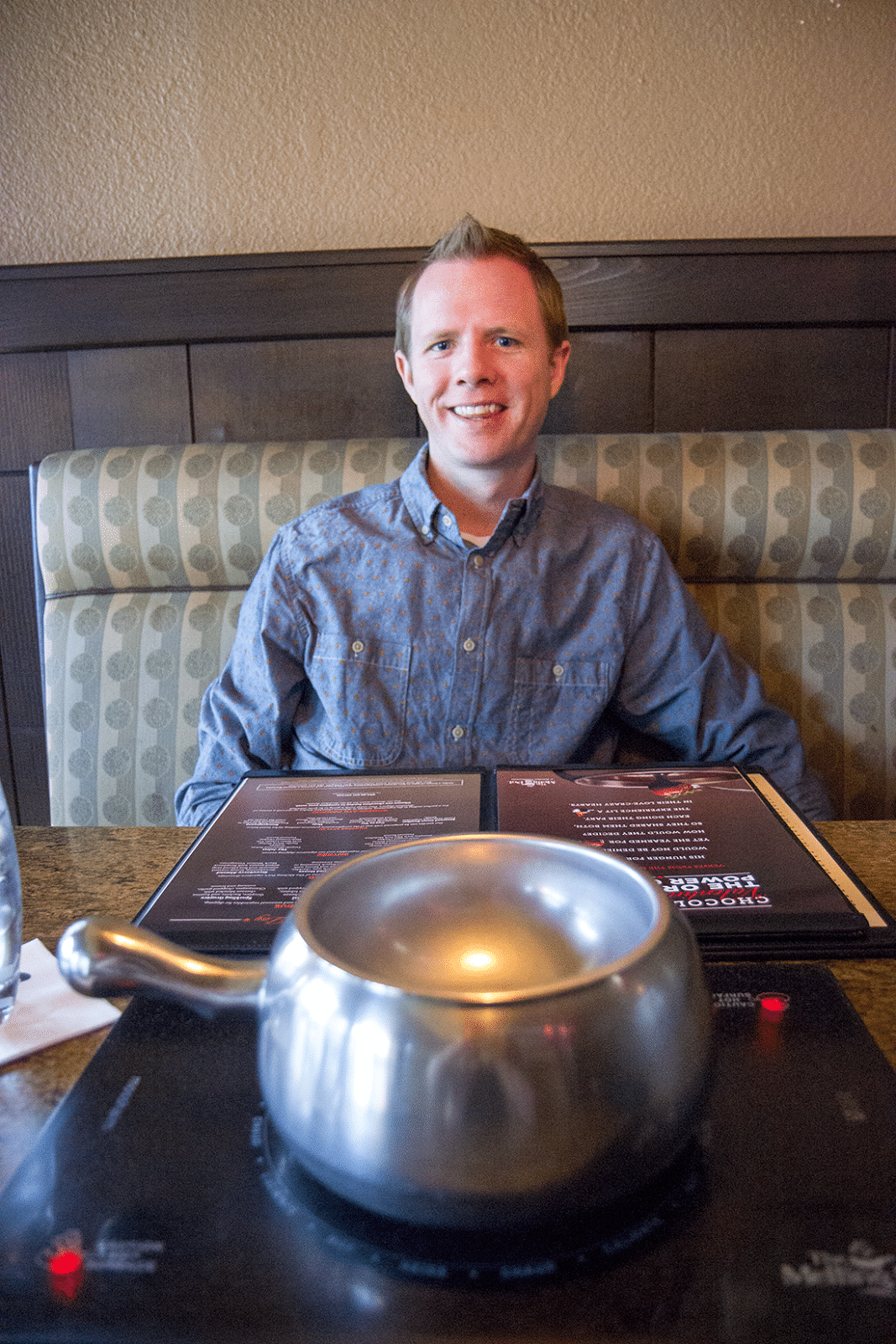 Man sitting in a bench ready for a fondue date at the Melting Pot. 
