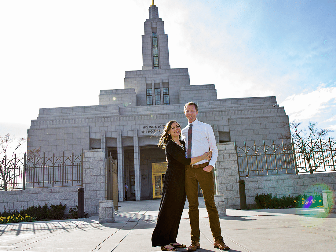 A couple standing in front of the Draper Utah Temple. 