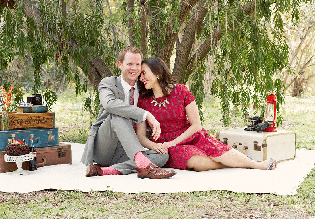 Cute couple taking anniversary pictures on a picnic blanket. 