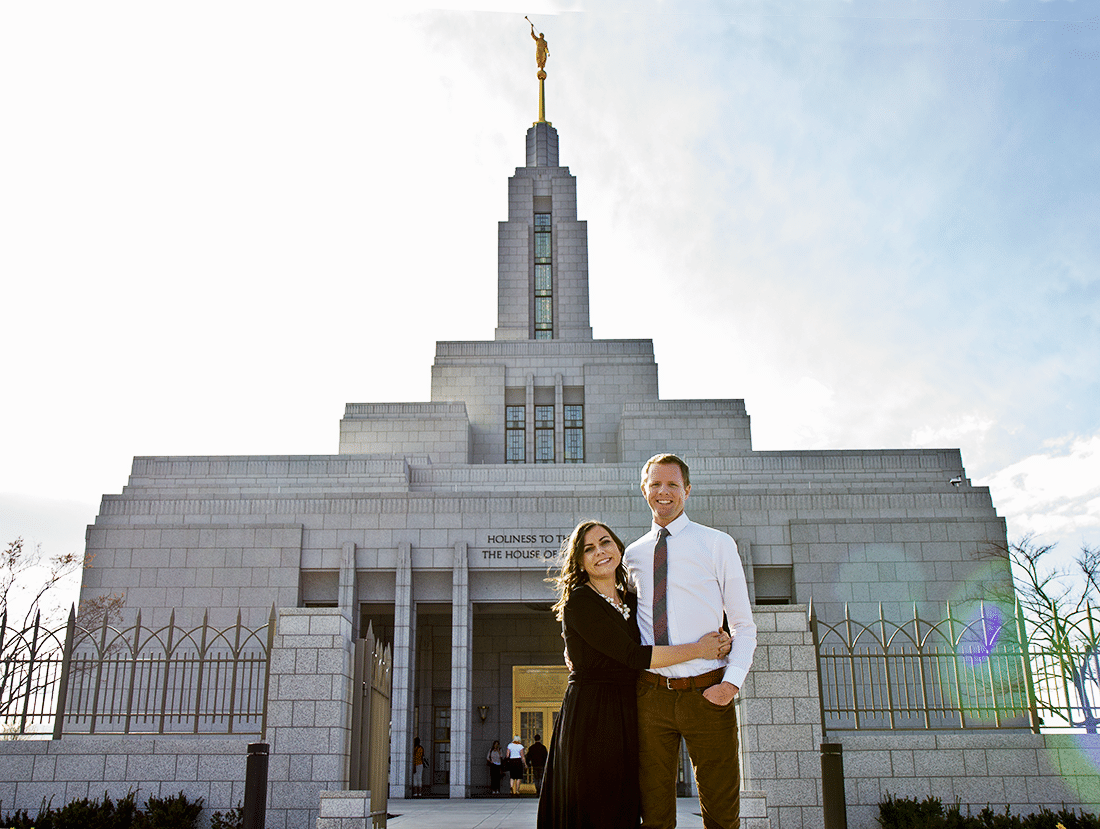 A couple standing in front of The Draper Utah Temple. 