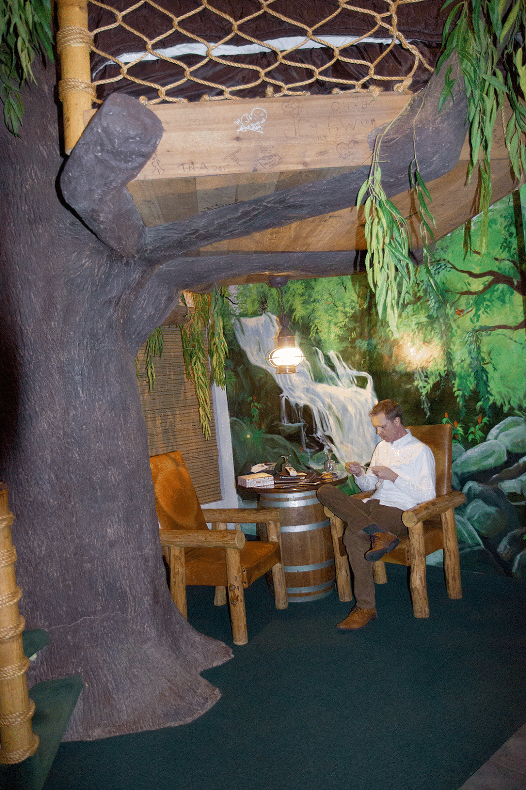 Man enjoying breakfast at Waterfall jetted tub at the Swiss Family Robinson Room at the Anniversary Inn. 
