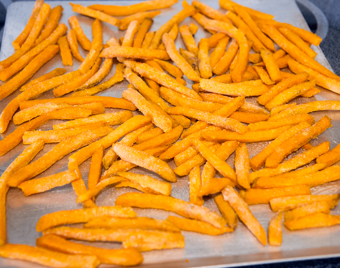 Frozen sweet potato fries on a sheet pan. 