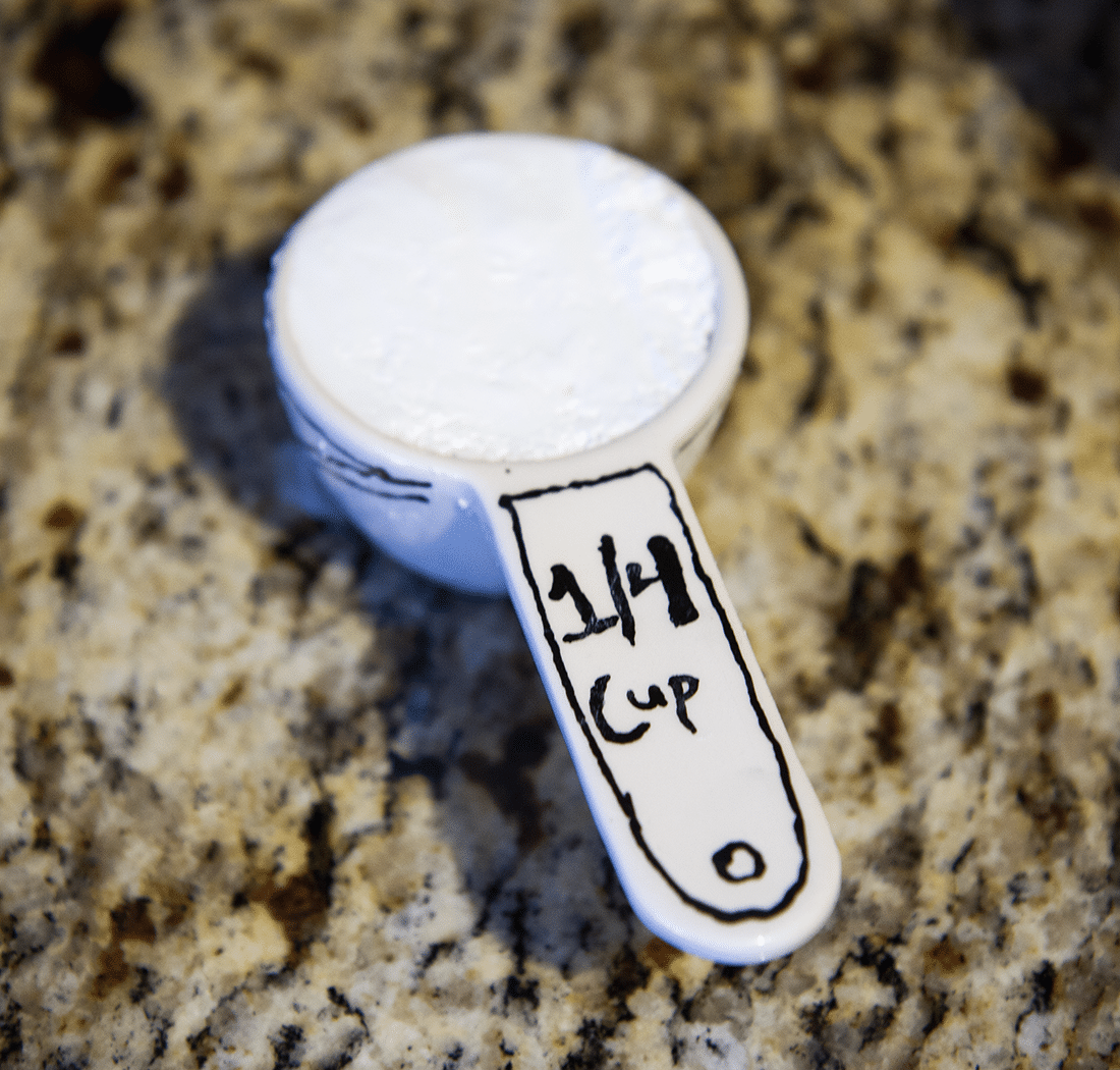 Custom painted measuring cup full of sugar. 