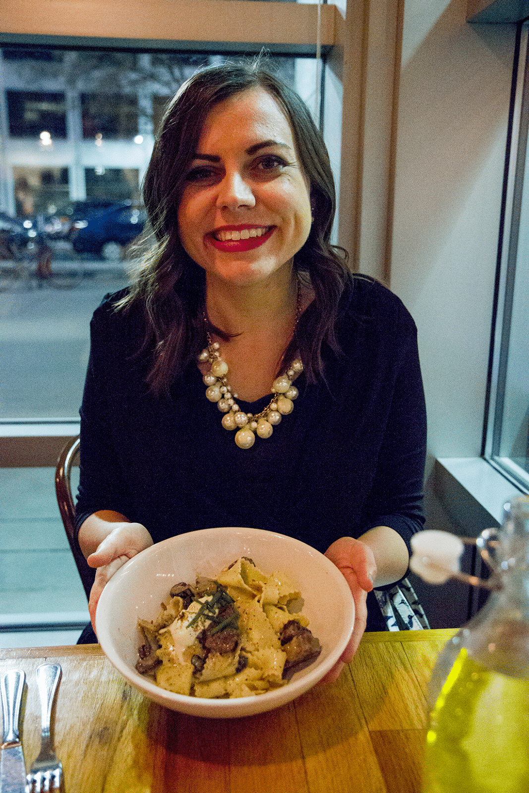 Woman showing her plated meal at The Copper Onion. 