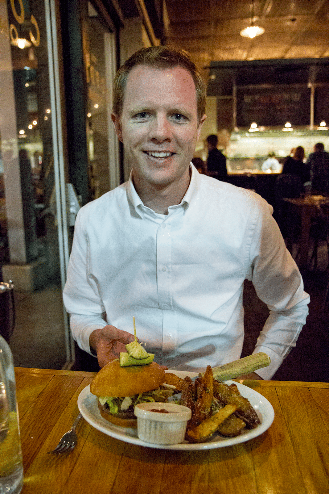 Man showing her plated meal at The Copper Onion. 