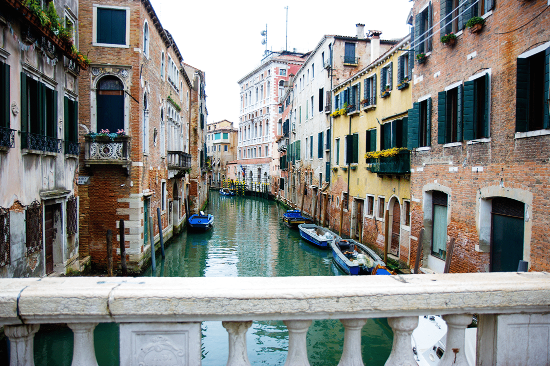 Venice, Italy canals with boats next to colorful buildings. 