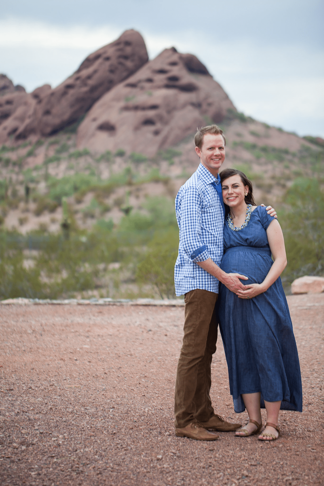 Couple posing for maternity pictures at Papago Park in Arizona. 