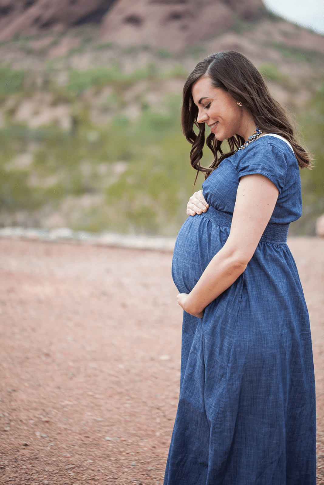 Mom looking at baby bump during a maternity photo shoot. 