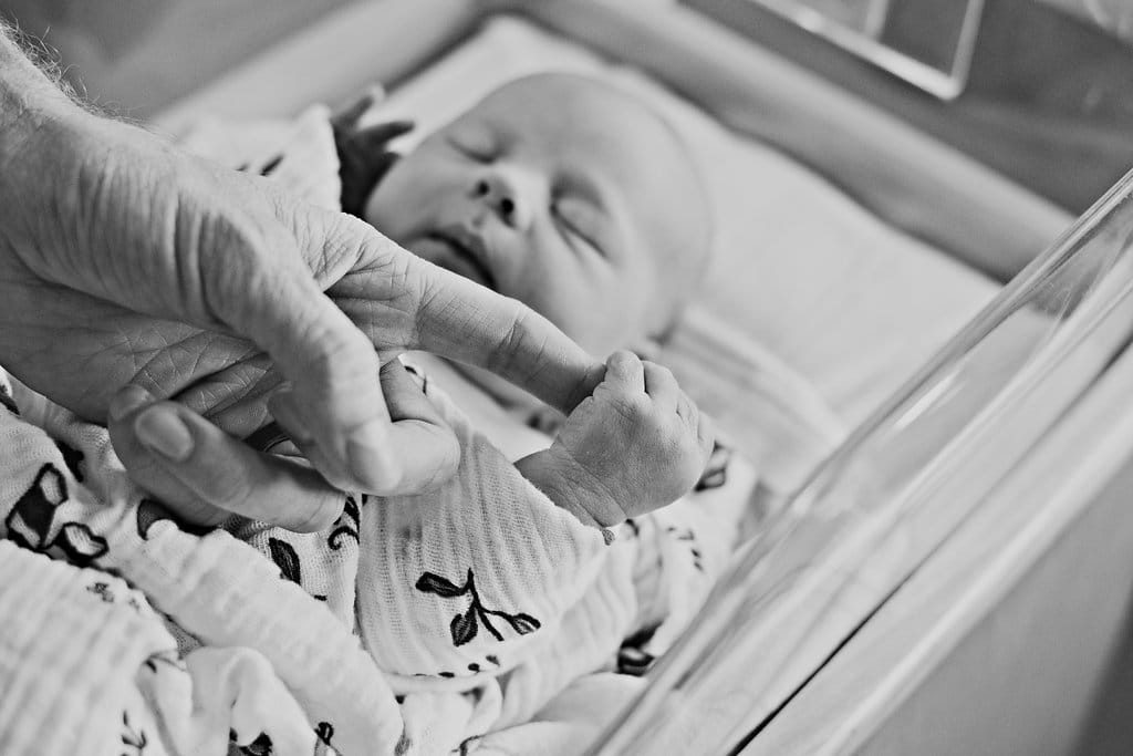 Birth Story Photography sharing a baby holding its mom's finger. 