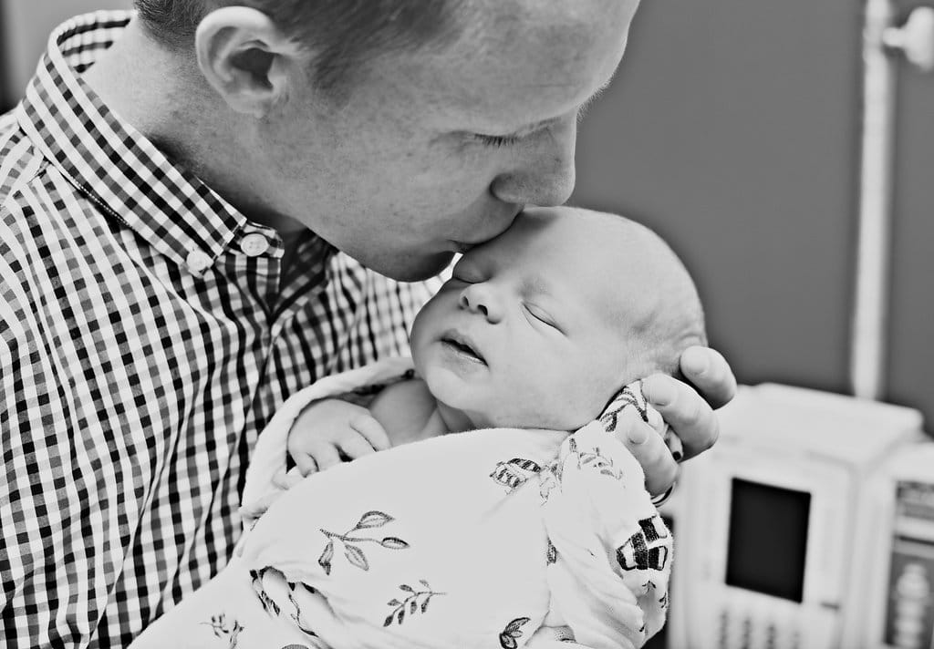 Shots to capture in a birth story: dad kissing the newborn baby's head. 