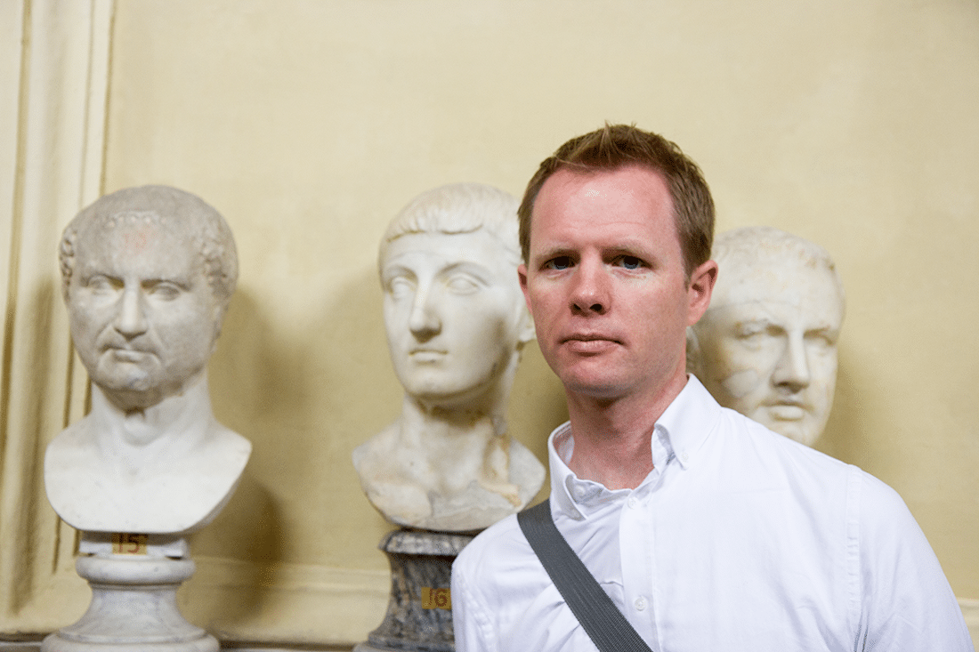 A man standing in front of bust statues at the Vatican in Rome, Italy. 