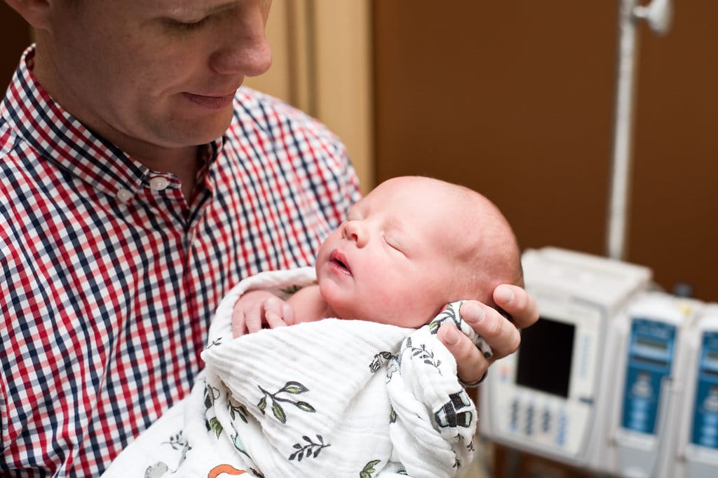 Birth Story Photography: dad holding their newborn baby. 