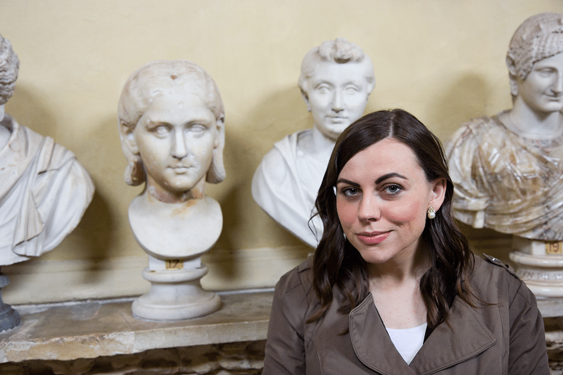 A woman standing in front of bust statues at the Vatican in Rome, Italy. 