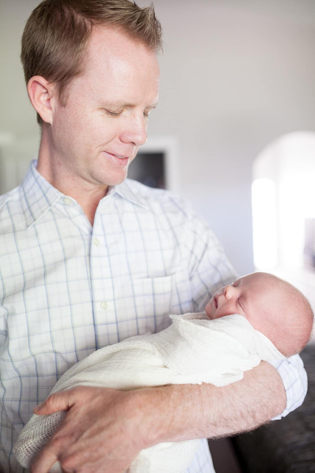 Dad holding his newborn baby at home. 