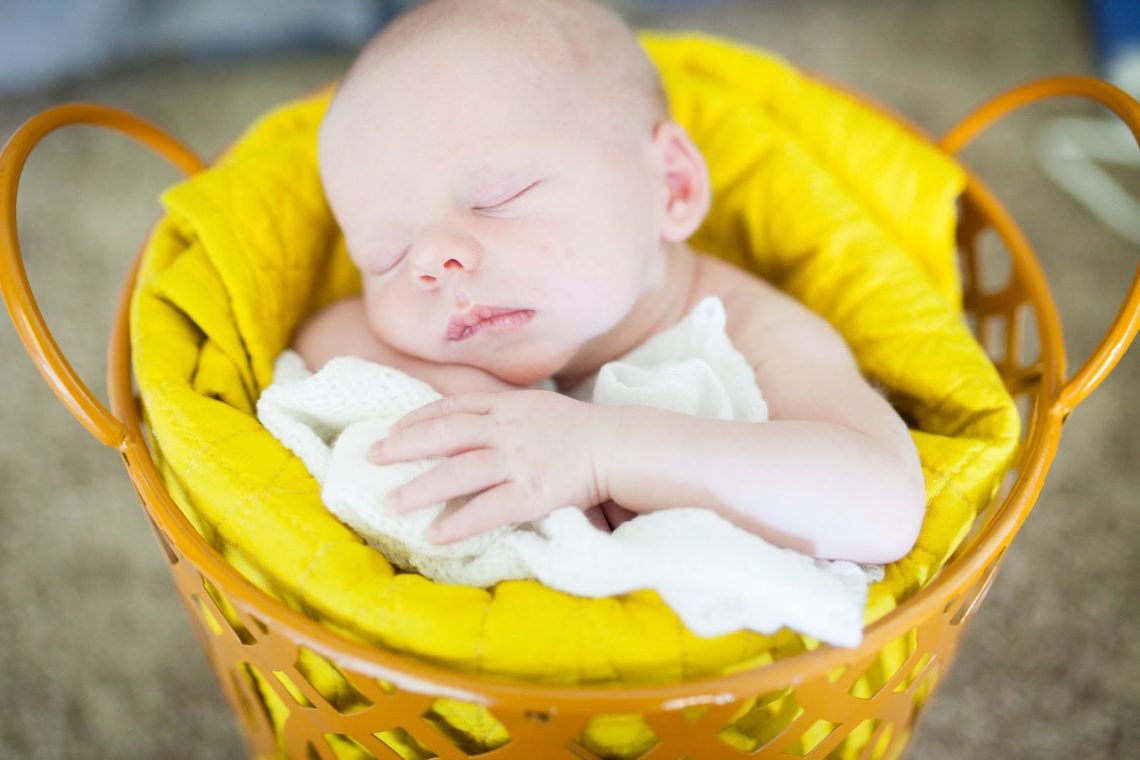 Baby asleep in a basket during newborn pictures. 