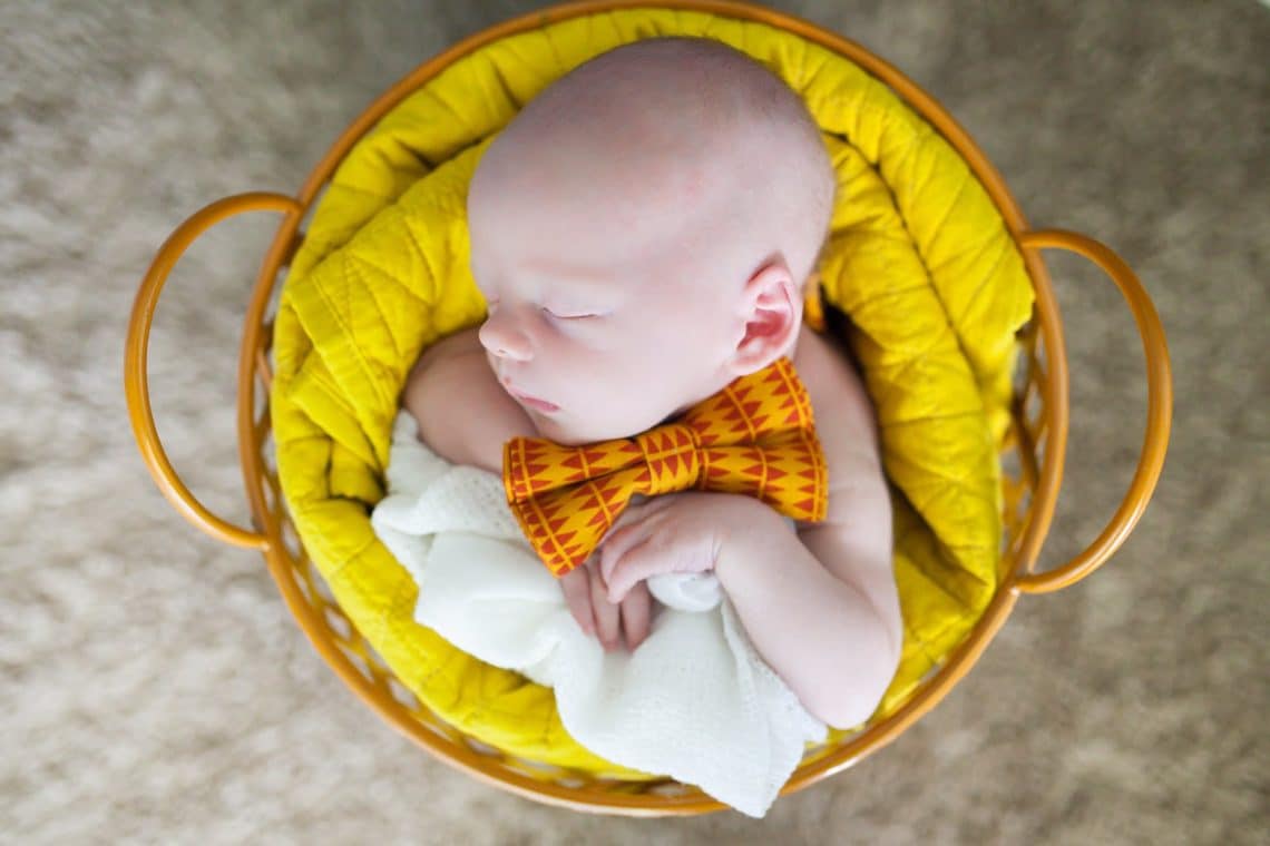 Newborn baby asleep in a basket. 